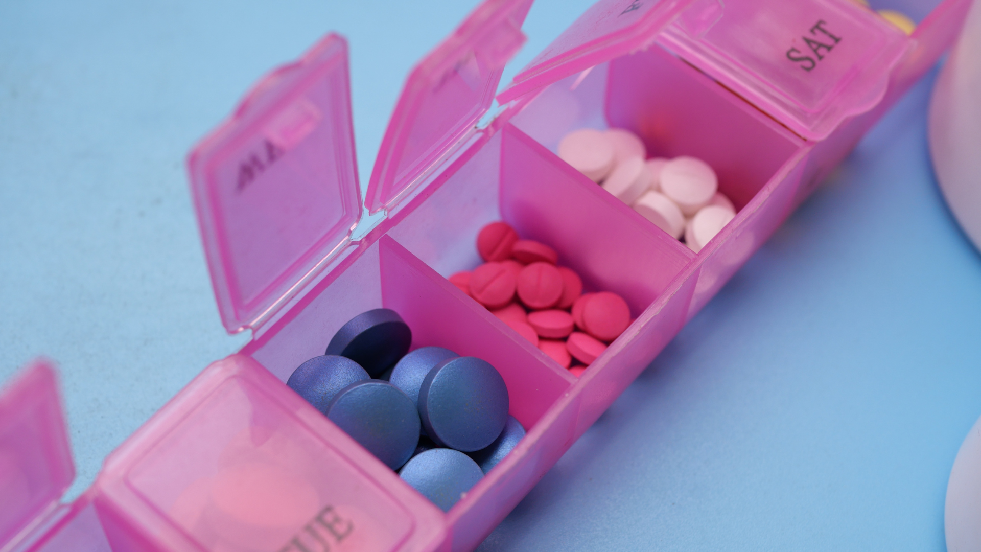 Person checking a missed dose of medicine on a pill organizer